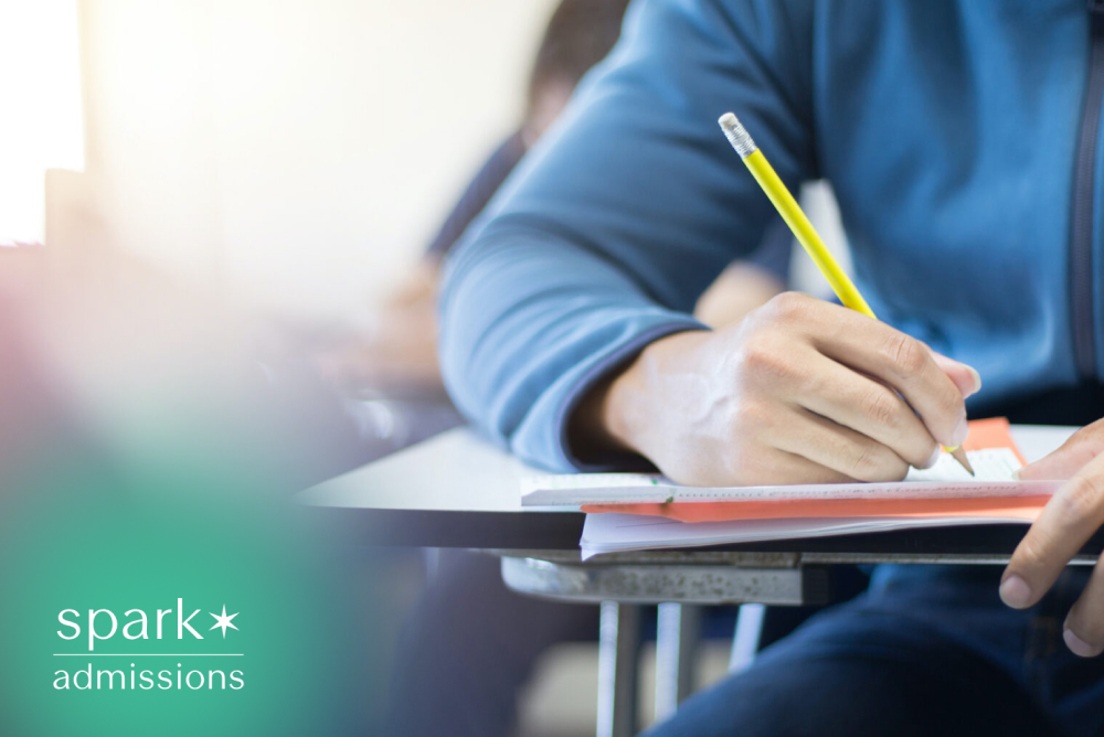 Student writing answers during a classroom exam with a pencil