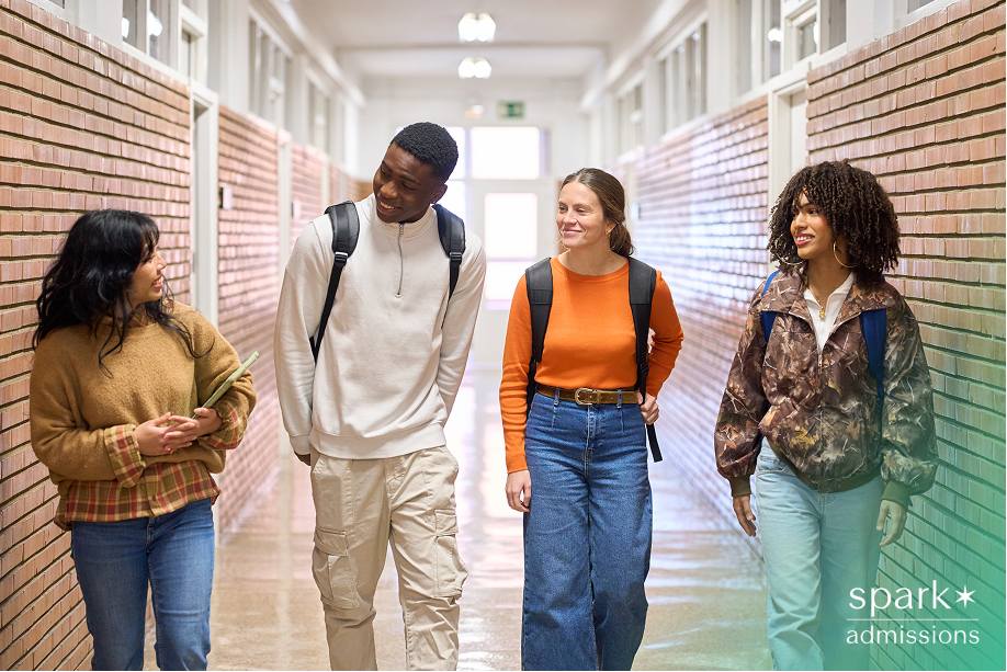 Four students walking down a school hallway while having a conversation