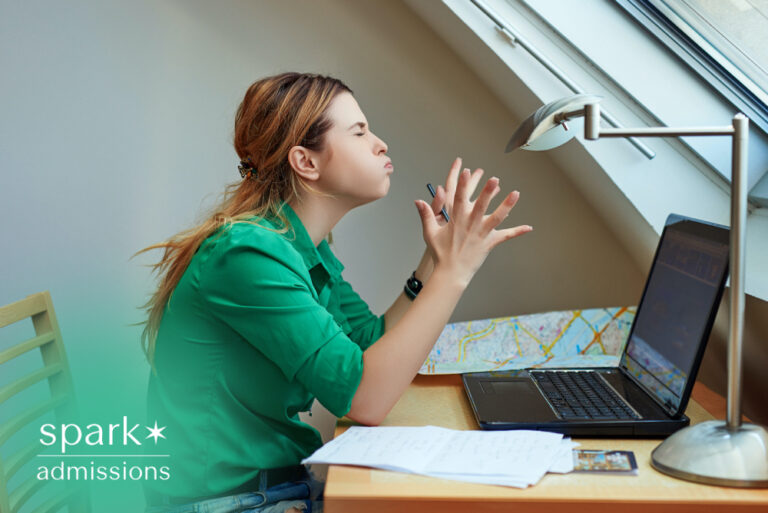College student looking frustrated while studying at a laptop with notes on the desk, illustrating academic stress, online learning, and exam preparation.