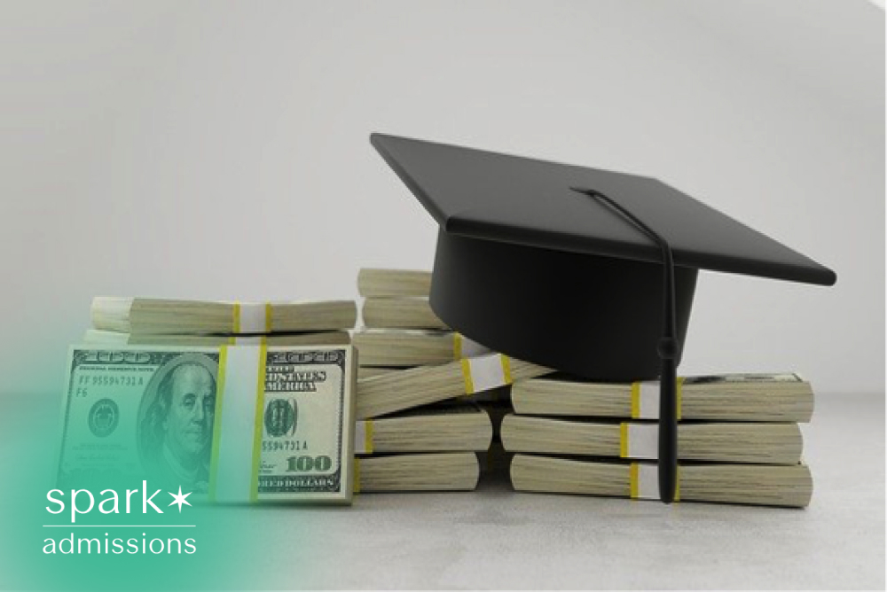 Graduation cap resting on stacks of U.S. dollar bills, representing college tuition costs, financial aid, scholarships, student loans, and higher education expenses.