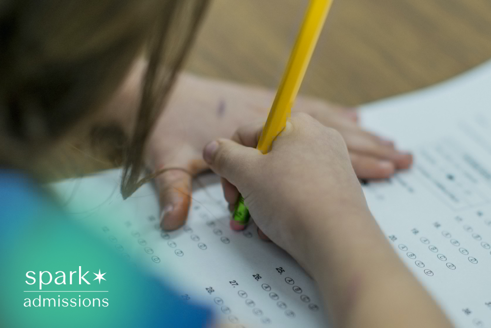 Student filling out a standardized test answer sheet with a pencil during an exam, focusing on multiple-choice responses.