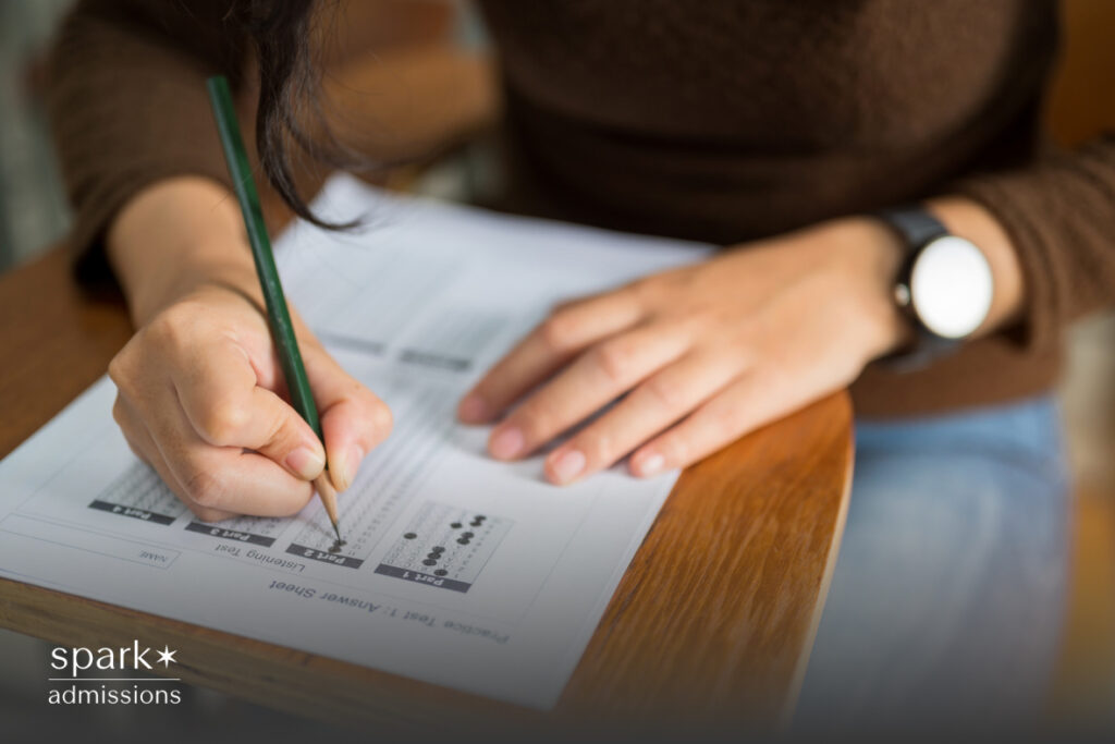 A student uses a pencil to fill in answers on a standardized test form during an exam