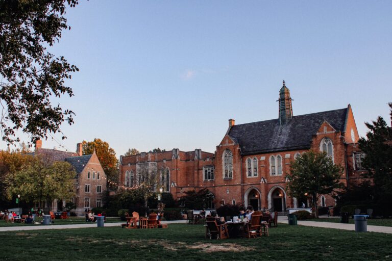 View of Ivy League campus with gothic architecture, under string lights during early evening