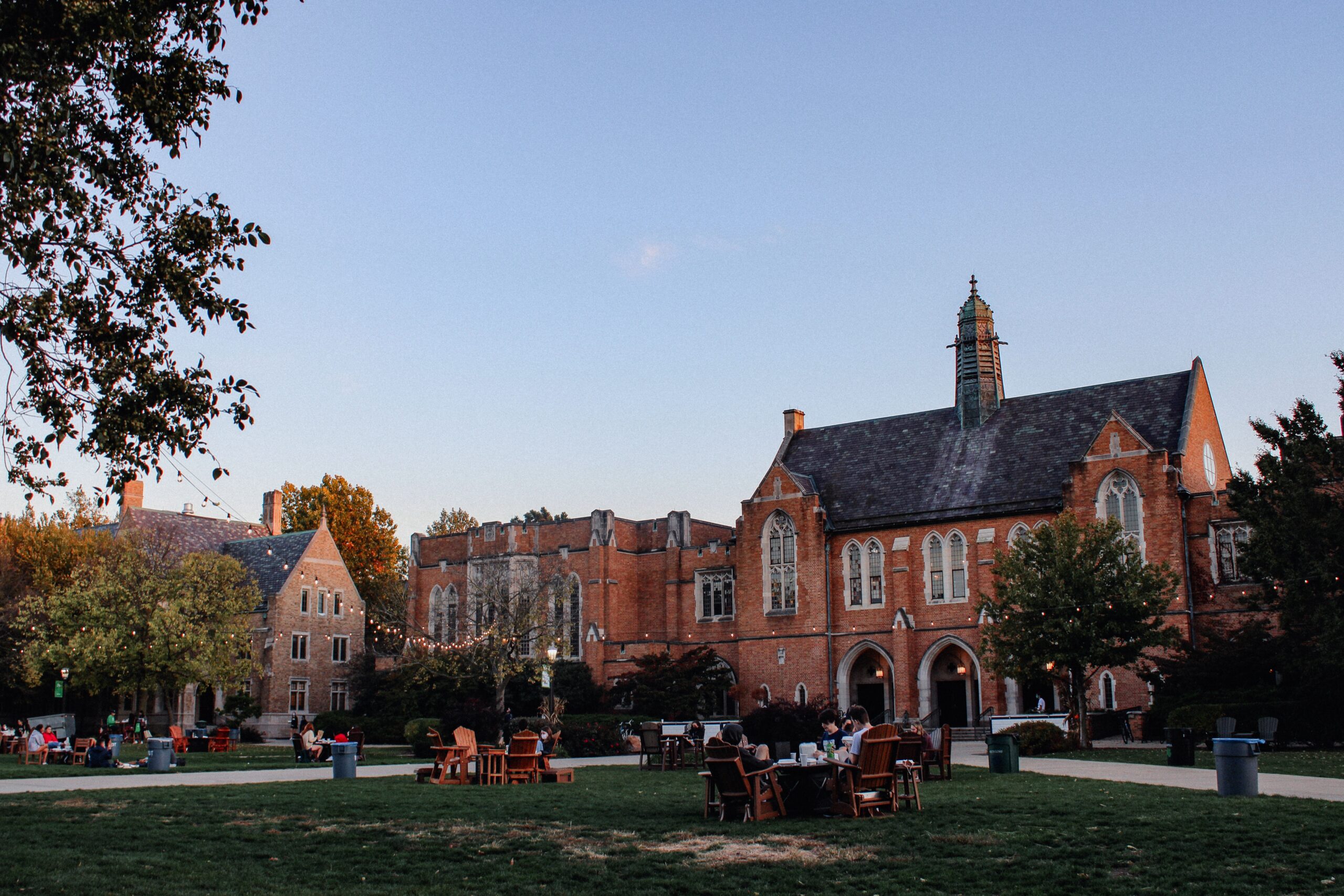 View of Ivy League campus with gothic architecture, under string lights during early evening