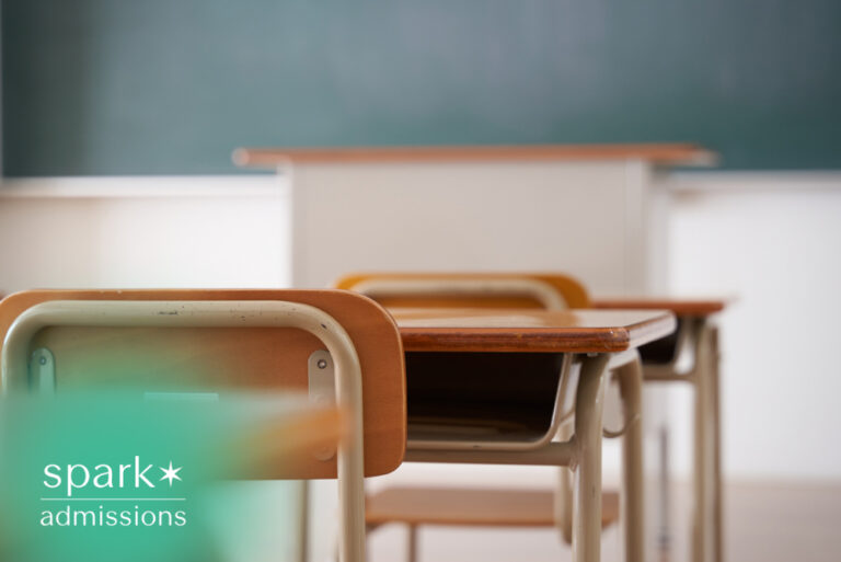 Empty classroom with student desks facing a chalkboard at the front of the room
