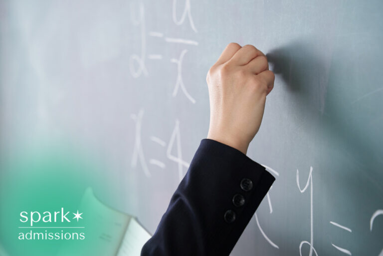Teacher writing math equations on a classroom chalkboard during a lesson