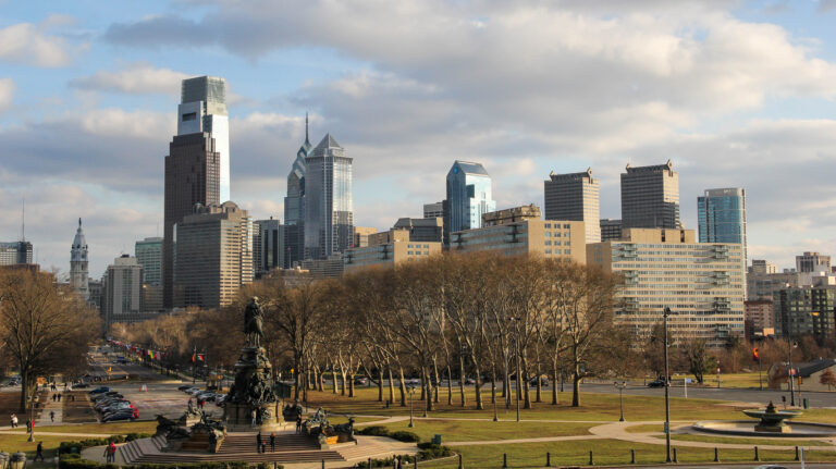 A wide view of University of Pennsylvania, The Wharton School skyline with tall buildings, and bare trees