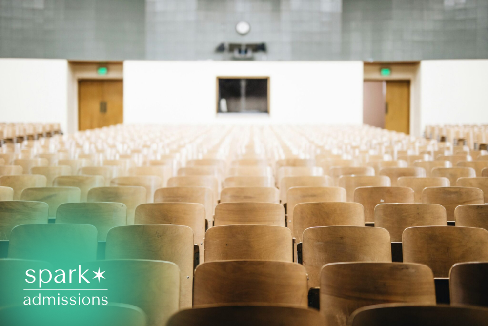 Empty university lecture hall with rows of wooden seats, representing higher education, college classrooms, campus life, orientation, and academic learning.