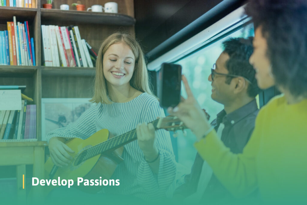 A woman playing a guitar in a school setting while two people sit nearby, watching and listening attentively