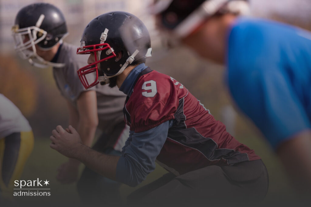 High school football players in helmets and uniforms line up on the field before a play