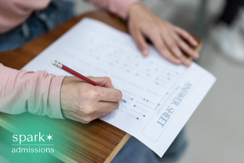 Student filling out a standardized test answer sheet with a pencil during an exam, representing college entrance testing and admissions preparation.