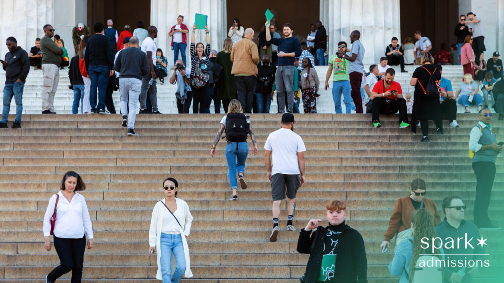 People walk up and down wide stone steps in front of a large, columned public building