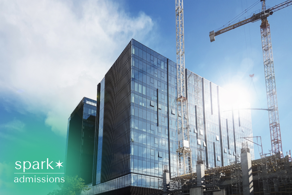 Modern campus building under construction with cranes
