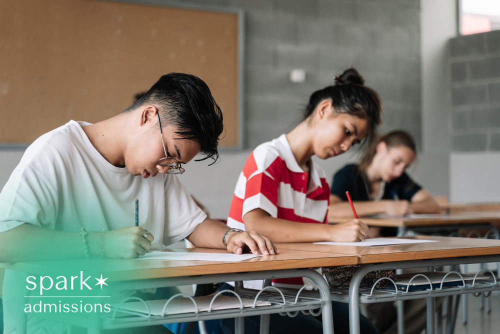 College students taking a written exam in a classroom with focused concentration.