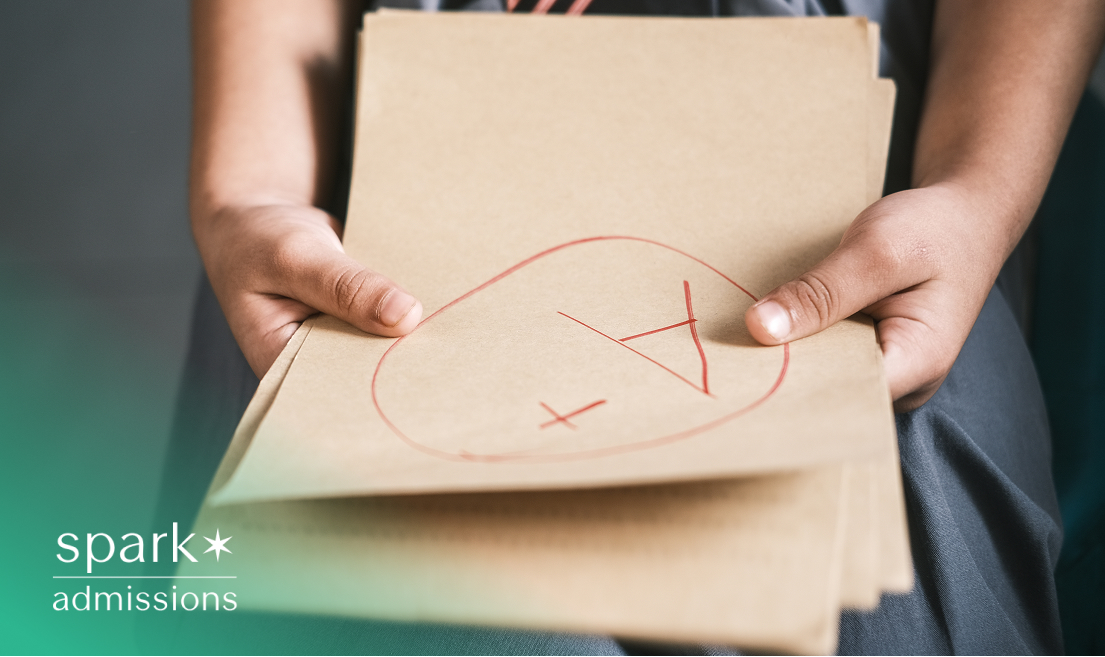 Close-up of a student holding a folder with an A+ grade marked in red on the front