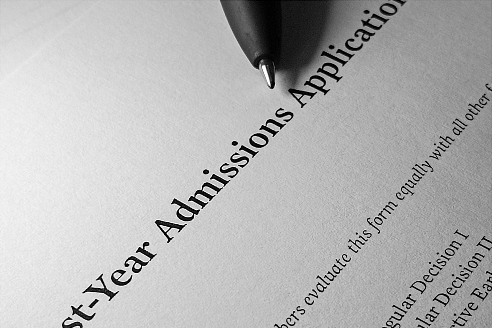 Close-up of a pen resting on a printed first-year college admissions application