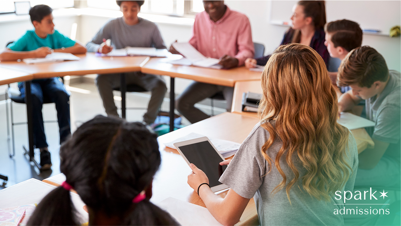 Middle school students in a round-table classroom discussion with a teacher