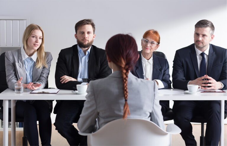 Candidate sitting across from four interviewers during a formal panel interview