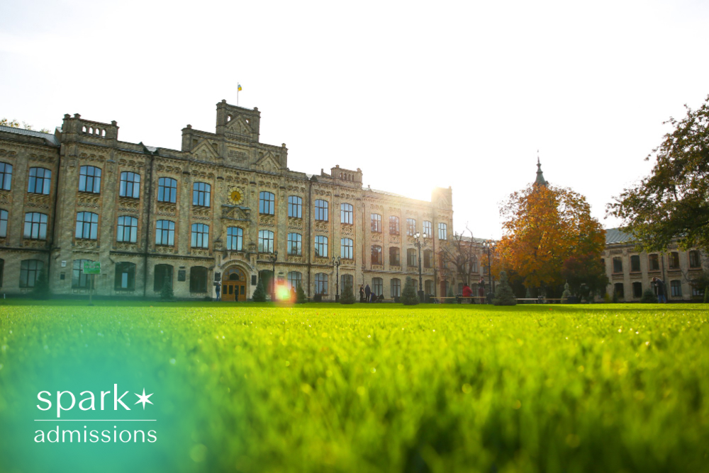 Historic university building with green campus lawn at sunset