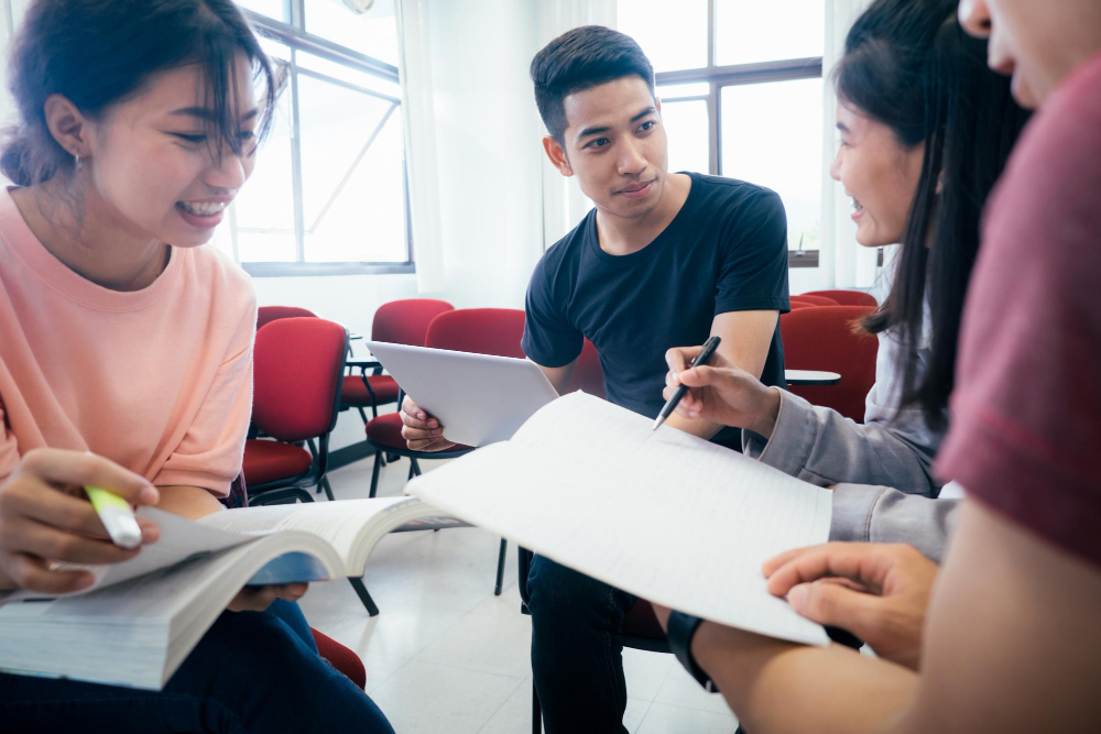 Group of college students gathered indoors having a conversation in a classroom or study lounge
