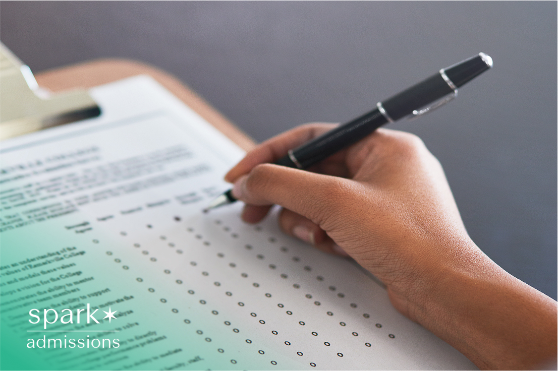 Hand filling out a multiple-choice answer sheet with a black pen