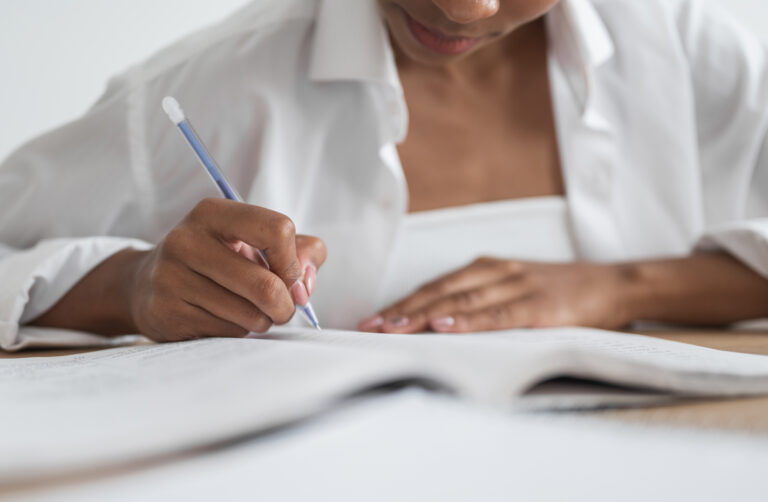 Close-up of a female student writing in a notebook