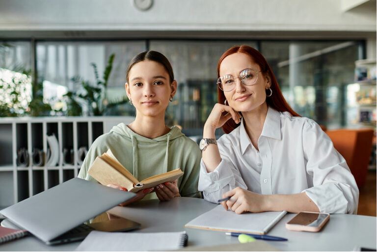 Junior student sitting with parents at a table covered in notes and papers, all looking engaged and thoughtful, discussing schoolwork or planning for education