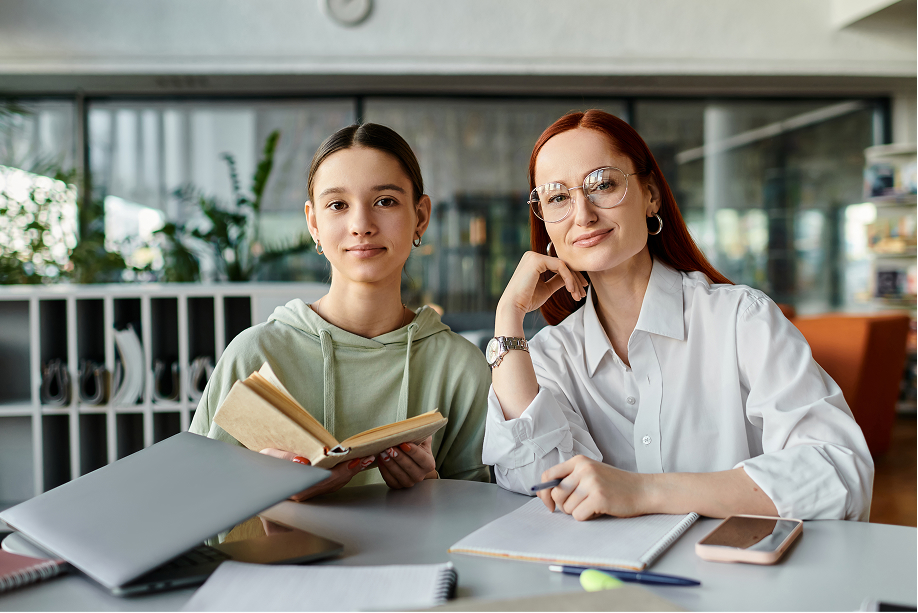 Junior student sitting with parents at a table covered in notes and papers, all looking engaged and thoughtful, discussing schoolwork or planning for education