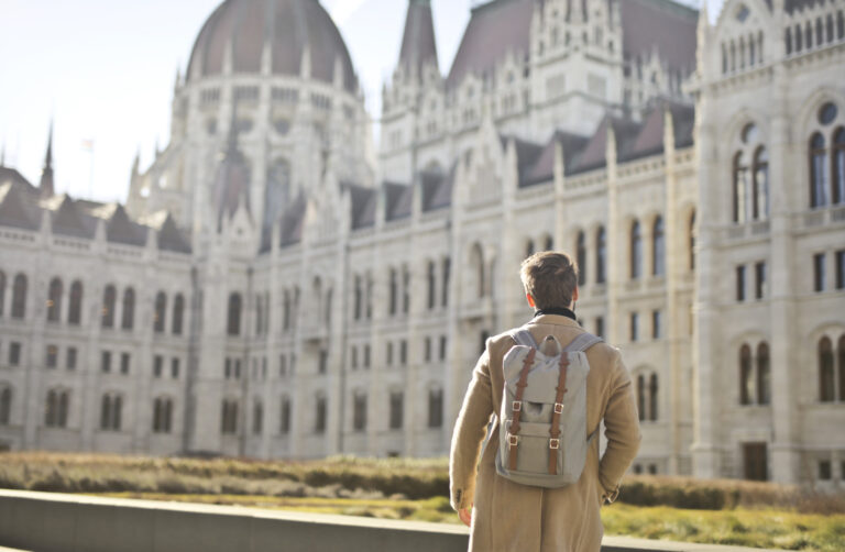 Student facing toward a school building, symbolizing ambition and future goals
