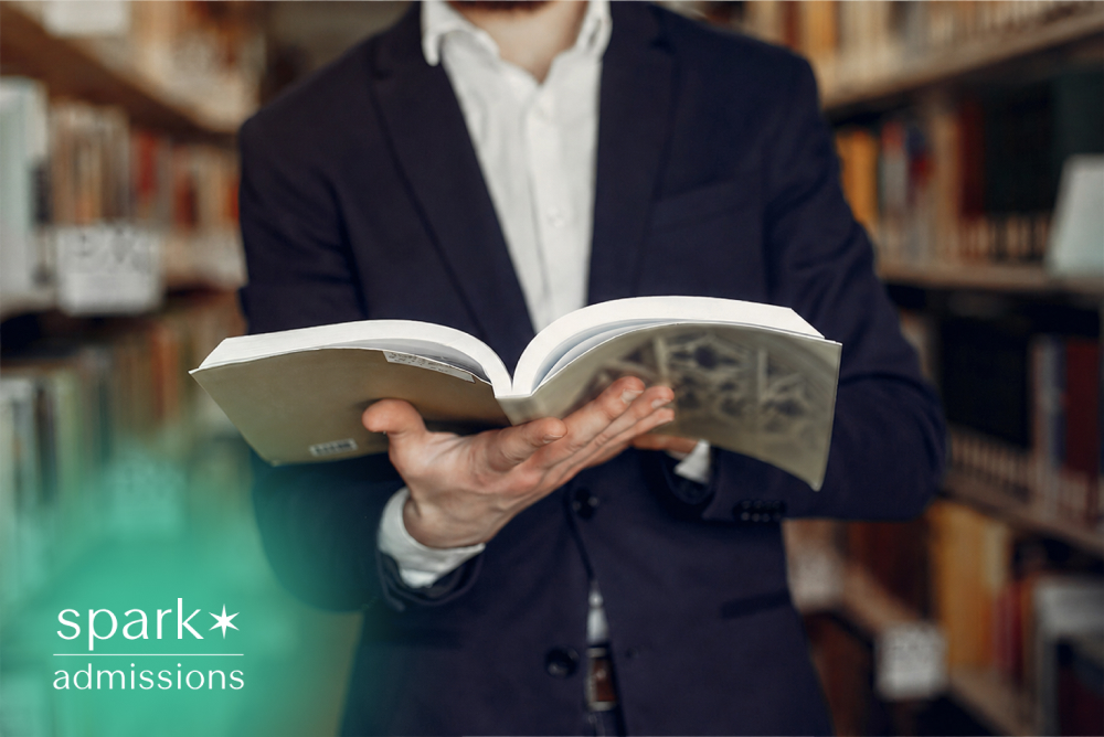 Admissions consultant reading a book in a library