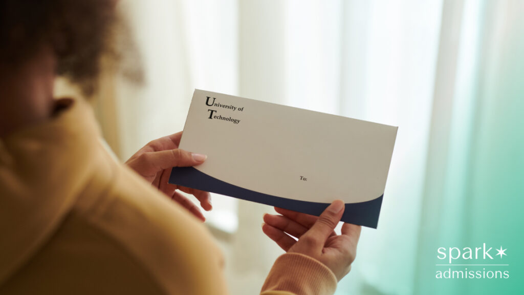 A student holds an admissions envelope from the University of Technology