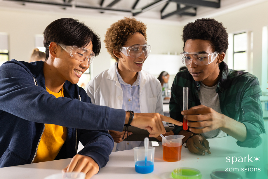 Three students wearing safety goggles conduct a chemistry experiment