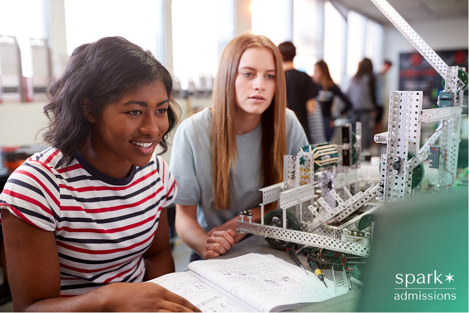 Two female college students work together on a robotics project in a classroom