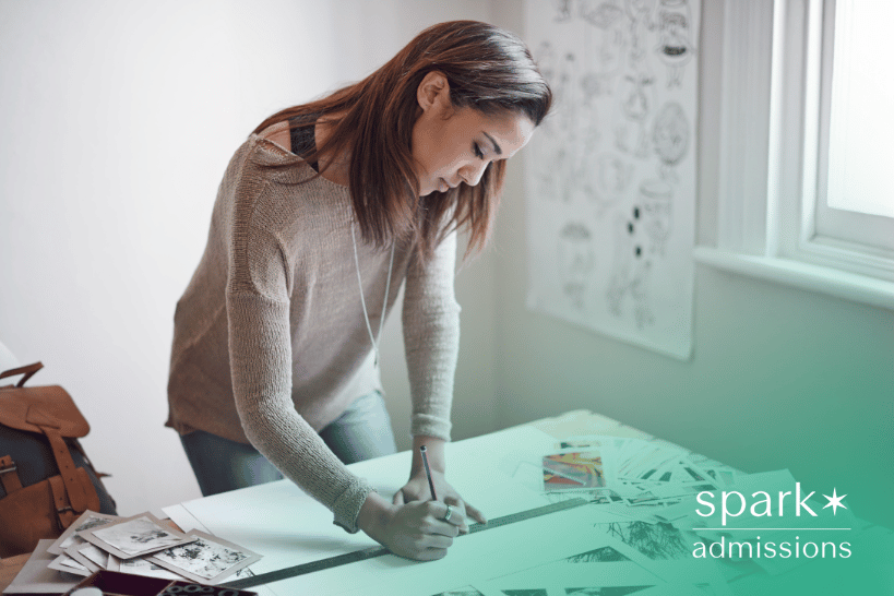 Woman drawing artwork on table for college art portfolio