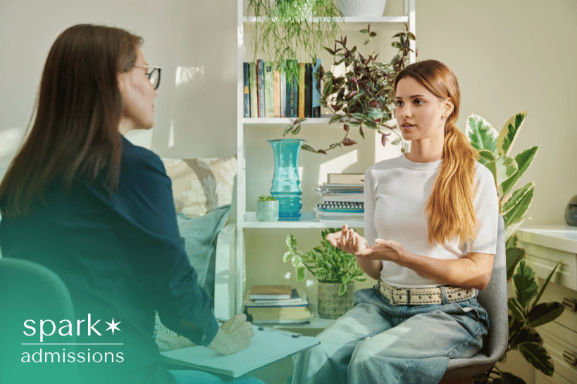 Female student discussing college admissions guidance with consultant in office