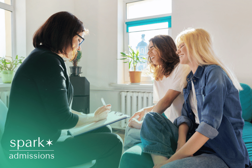 Two students meeting with female college admissions consultant for application advice