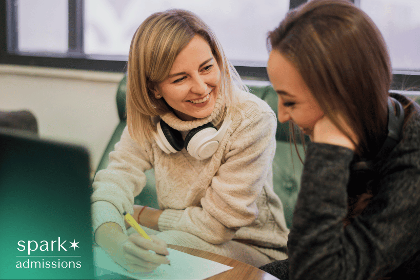 Female admissions consultant and student smiling during transfer essay consultation