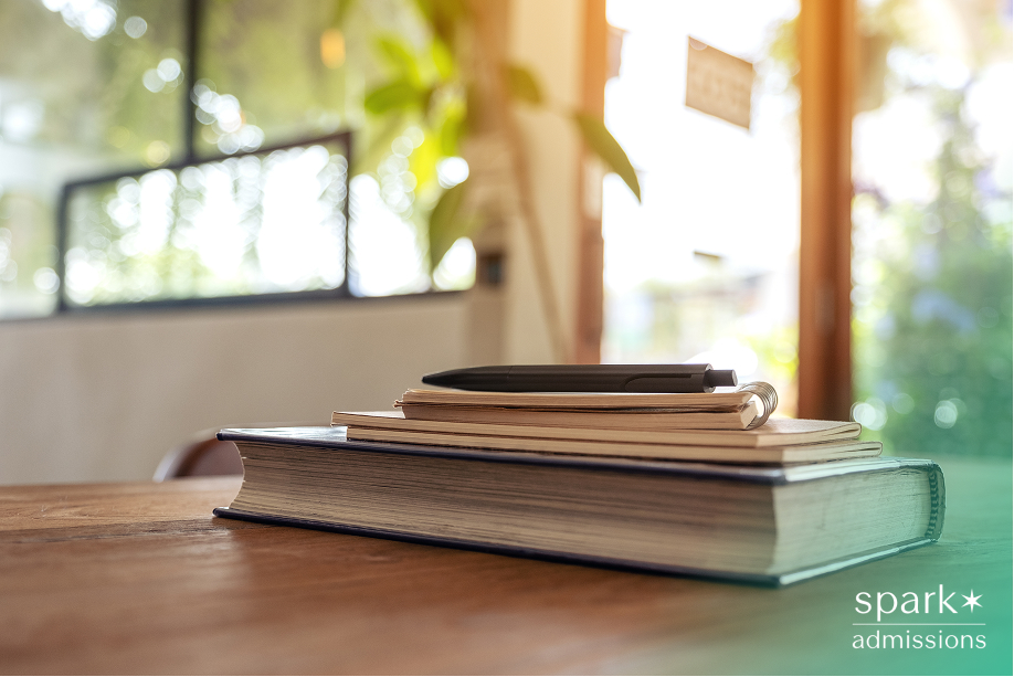 Books and notebooks stacked on a table, symbolizing academic planning for the summer before high school.