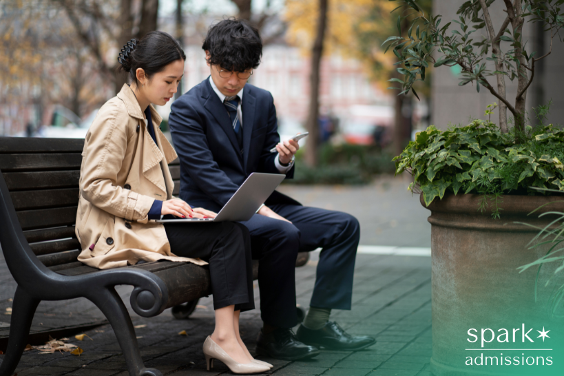 Students researching top undergraduate business schools in Texas on a laptop outdoors.