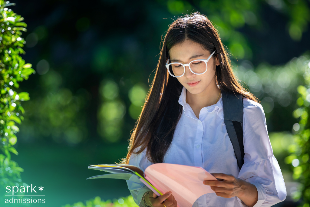 College student reviewing transfer credit documents in hand