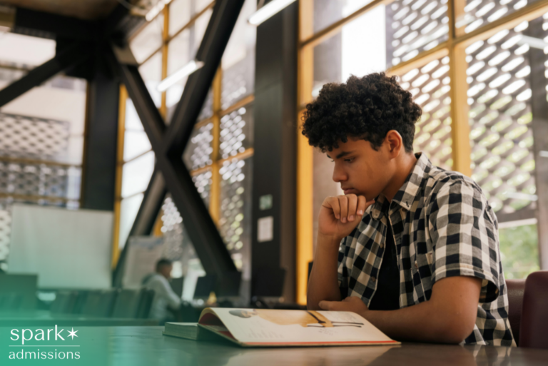 High-achieving student with autism studying and reading a book while preparing for college admissions