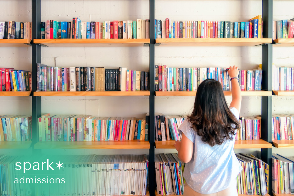 Student reaching for books on colorful library shelves while studying