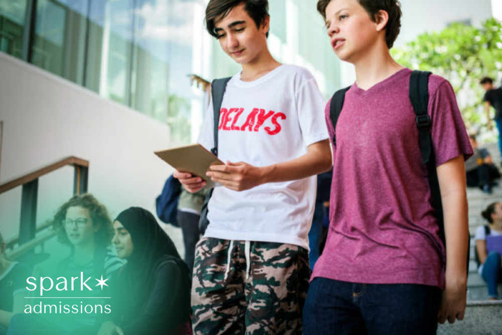 Students reviewing college planning details on a tablet while walking on campus