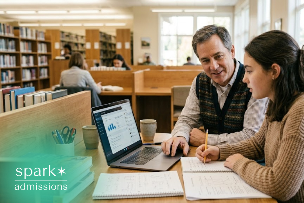 Student studying with tutor in library using laptop