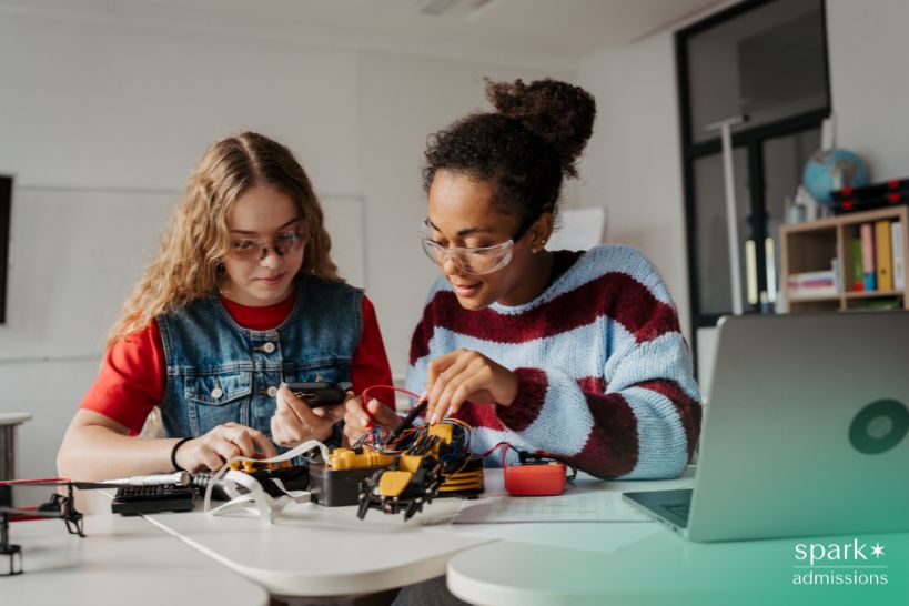 Students building a robotics and electronics project in a classroom with a laptop